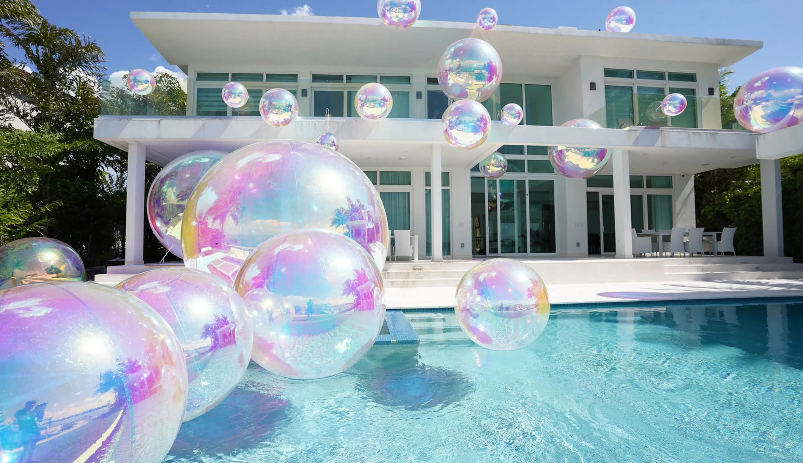 Giant iridescent inflatable spheres floating in pool