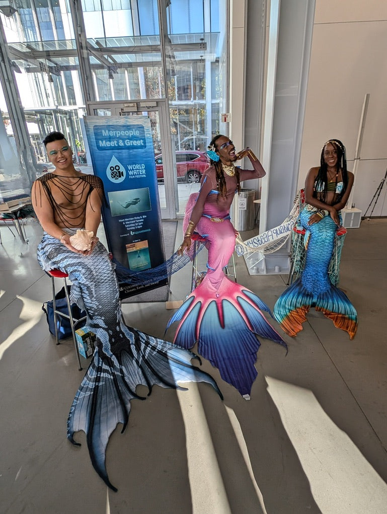 Three diverse AquaMermaid performers at a public event