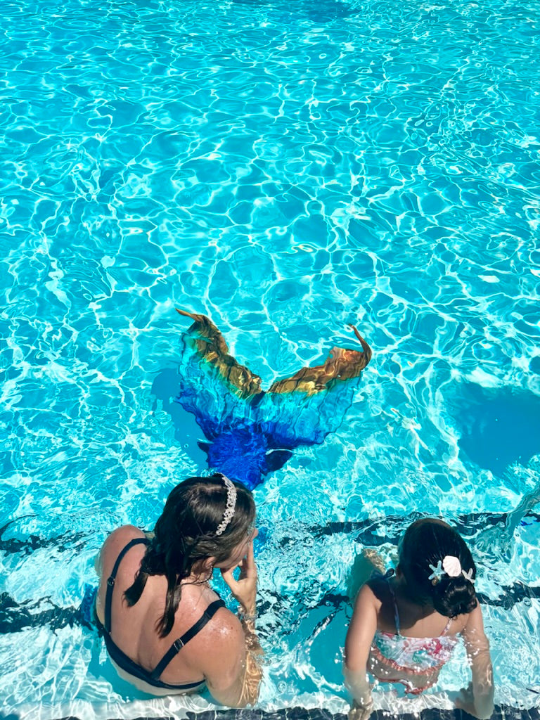 AquaMermaid performer with a child at a pool party