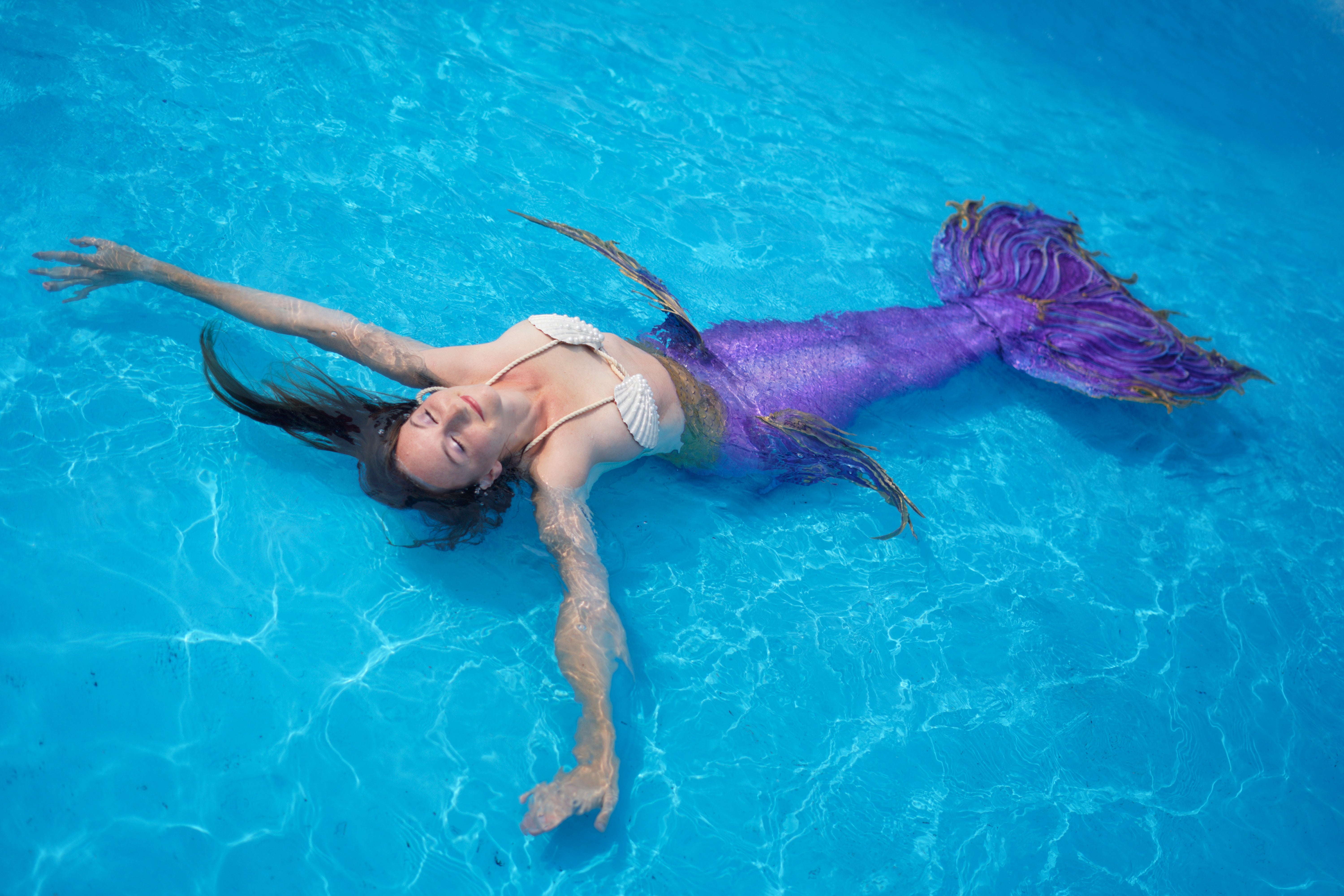 Mermaid performer floating in pool in Los Angeles